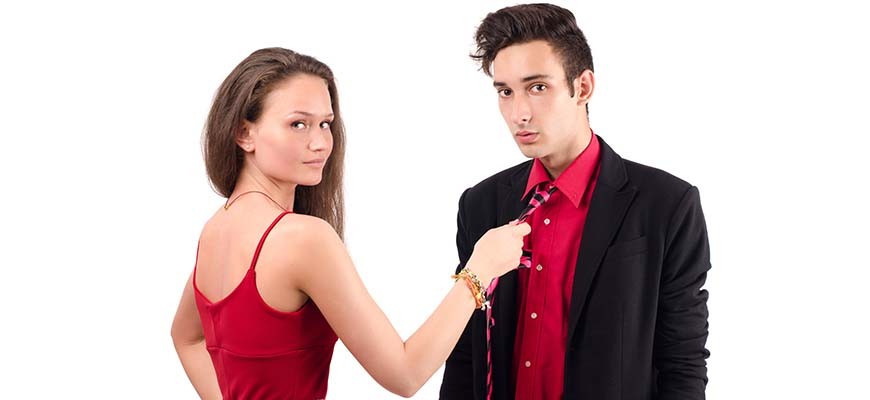 девушка держит мужчину за галстук